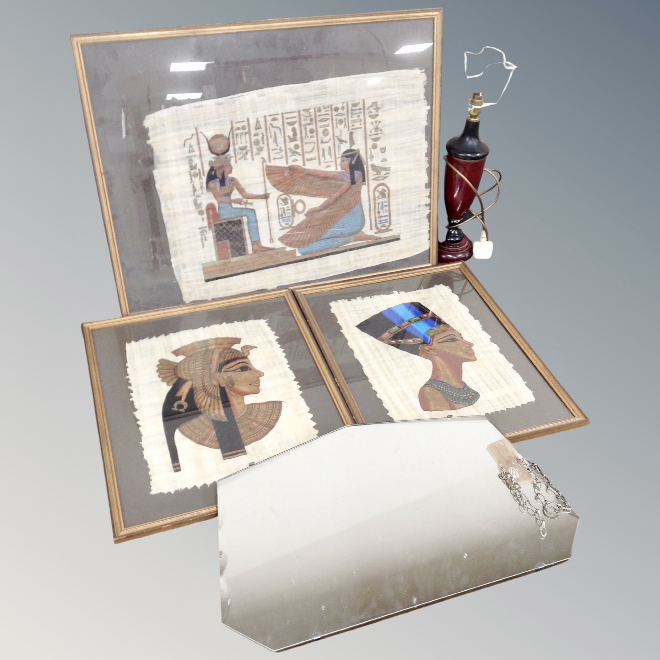 A 1930's frameless bevelled mirror together with three Egyptian style pictures, table lamp.