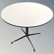 A contemporary circular bistro table on metal legs