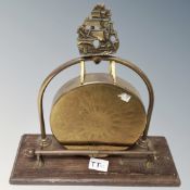 A vintage brass dinner gong mounted on a stand