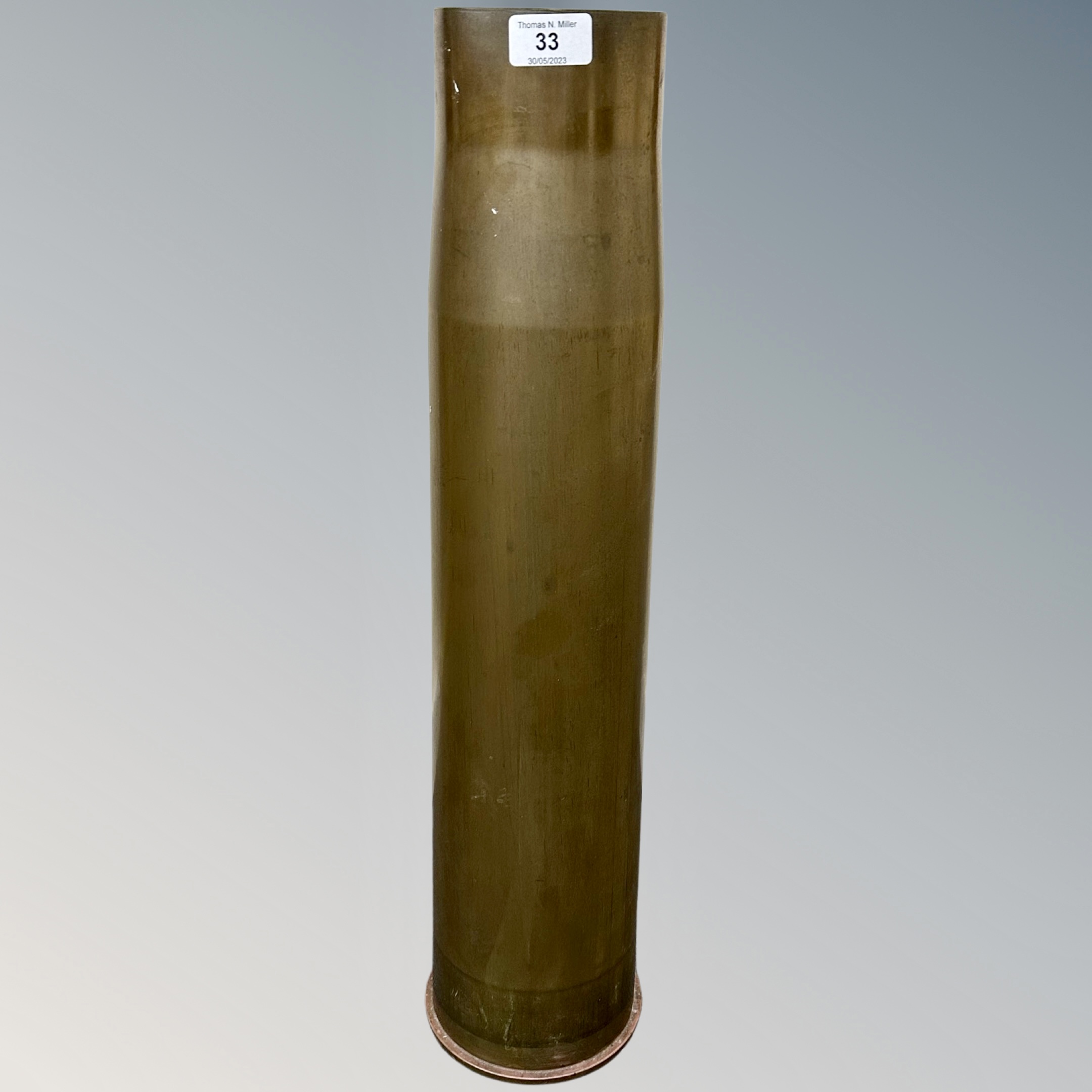 A heavy artillery brass ammunition shell casing, various engraved markings to base,