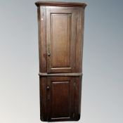 A George III oak single door corner cabinet