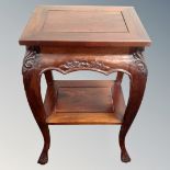 An eastern hardwood two tier occasional table on claw and ball feet