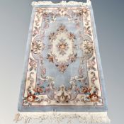 A Chinese fringed embossed rug on blue ground,