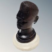 A carved hardwood African head on marble base,