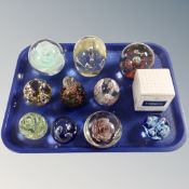 A tray of assorted glass paperweights,