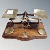 A set of antique post office scales with weights mounted on board