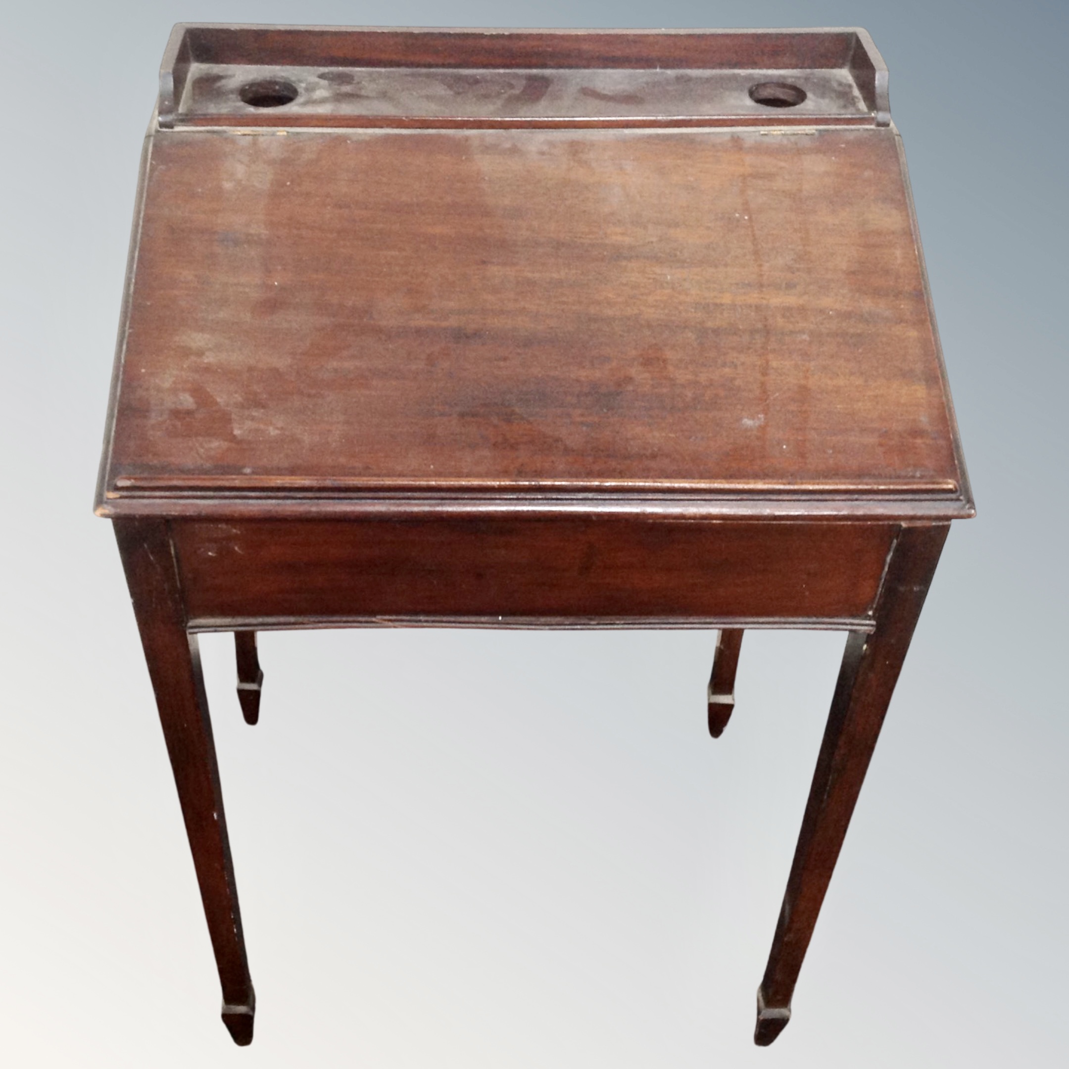 An Edwardian school desk on raised legs.