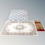 An Indian floral rug on cream ground together with two further woolen rugs
