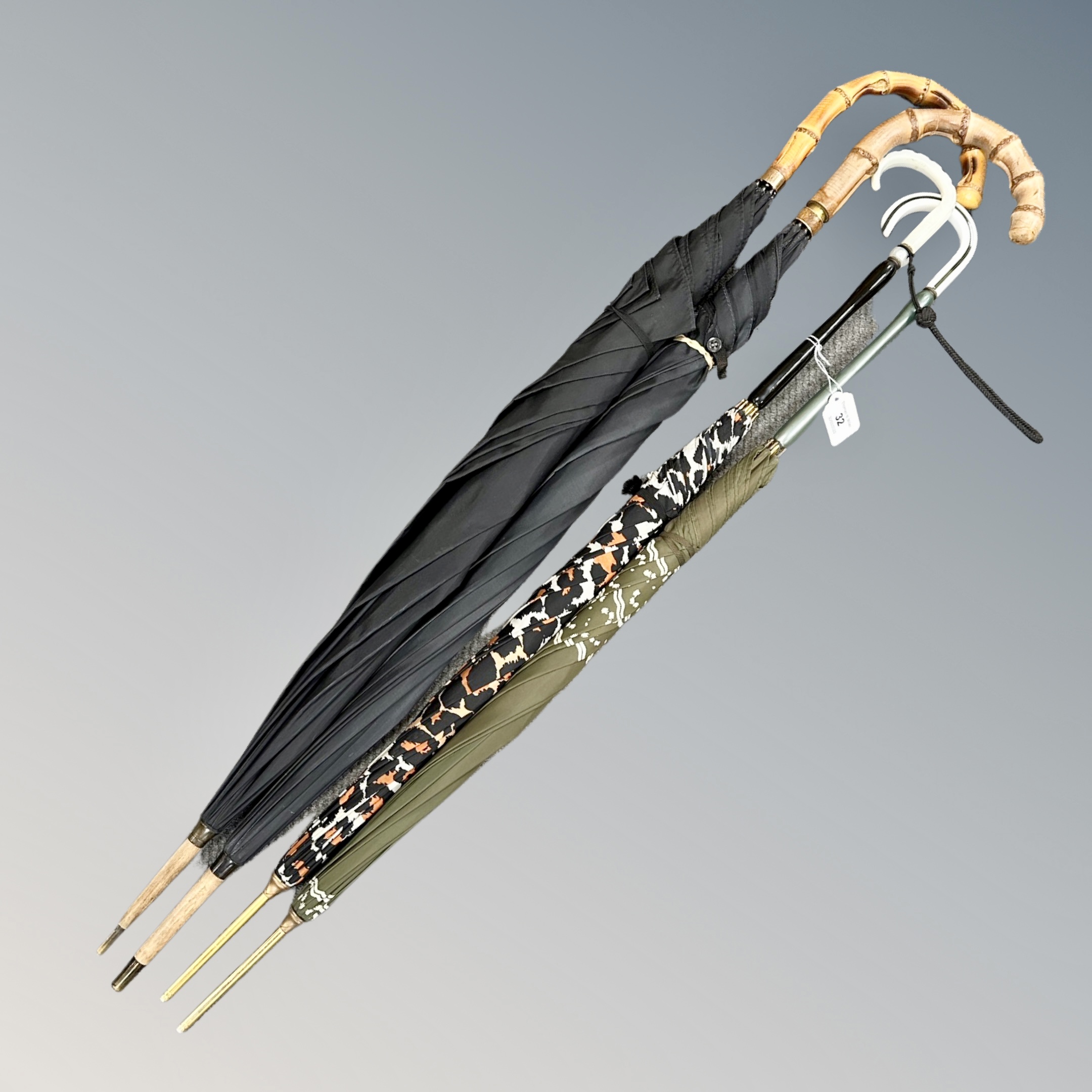 An antique parasol with 9ct gold plated ferrule, together with three further examples.