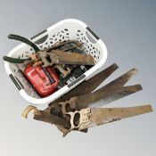 A basket of vintage tools, hand saws,