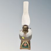 A Duplex oil lamp on ornate cast iron base with glass reservoir