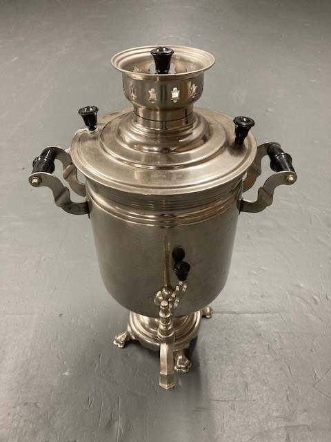 A stainless steel tea urn with tap
