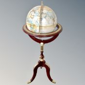 A Royal Geographical Society world globe on decorative tripod stand.