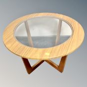 A 1970s circular glass topped occasional table in a teak-effect finish.