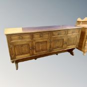 An oak Jacobean style four door sideboard on raised legs