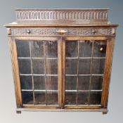 A late 19th century carved oak double door glazed bookcase.