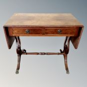 A Regency style flap-sided sofa table on brass capped feet.