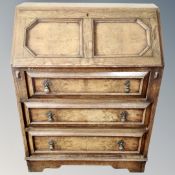 An Edwardian oak bureau fitted with three drawers.