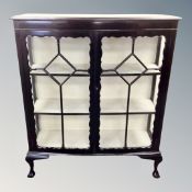 A late 19th century ebonised double door display cabinet on claw and ball feet