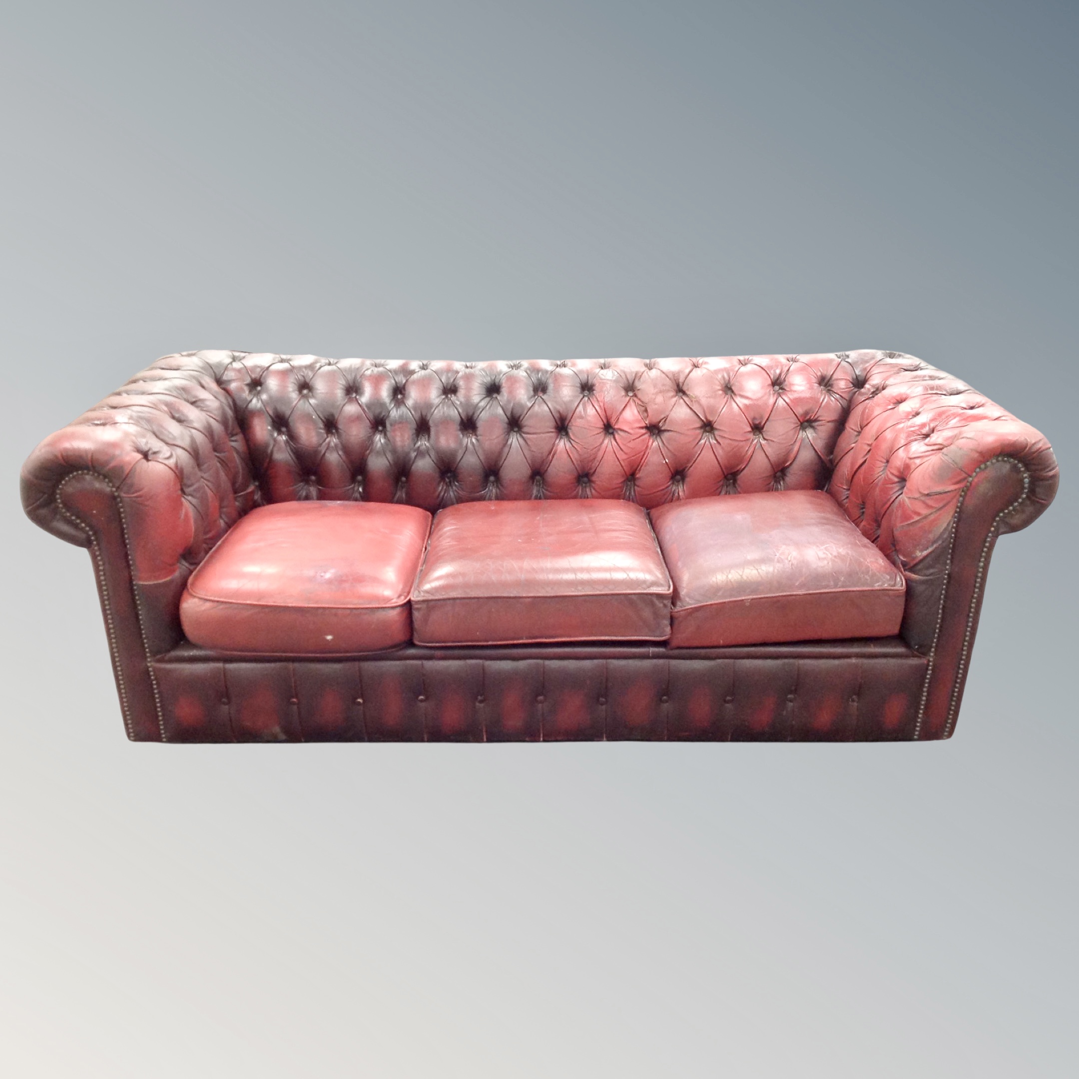 A three piece non-matching oxblood Chesterfield club suite (odd cushions)