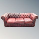 A three piece non-matching oxblood Chesterfield club suite (odd cushions)