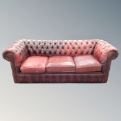 A three piece non-matching oxblood Chesterfield club suite (odd cushions)