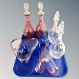 A tray containing a pair of crystal decanters, ruby tinted decanters etc.