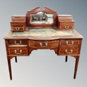 A Victorian shaped front inlaid mahogany writing desk on raised legs.