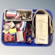 A tray containing a military issue cardboard box containing buttons, sew-badges, ID bracelet,