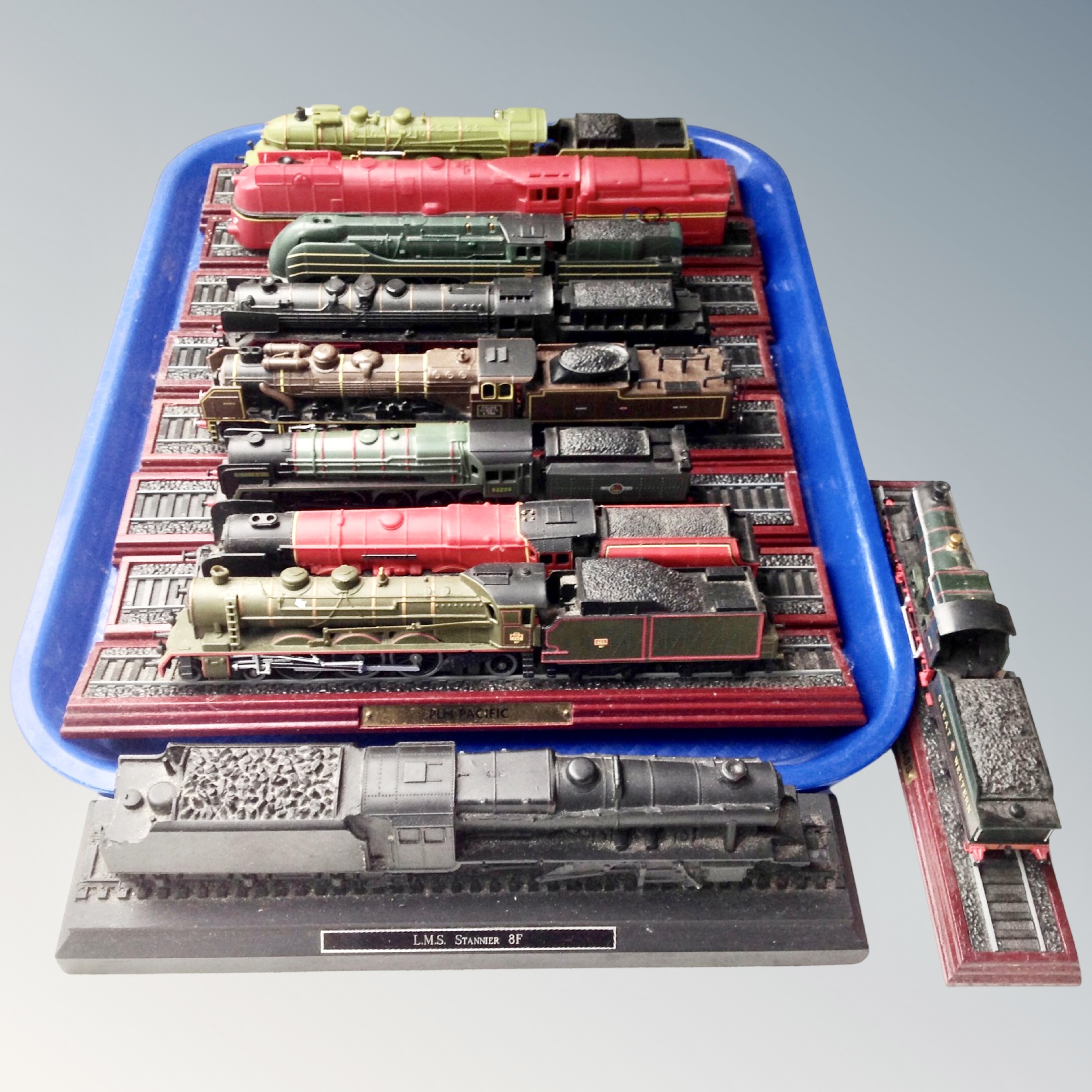 A collection of model train locomotives on plinths, prints of locomotives, etc.