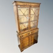 A Chapmans Siesta yew wood double door bookcase, fitted with cupboards and drawers beneath.