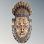 A solid carved West African face mask