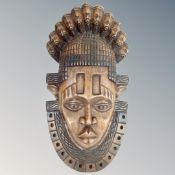 A solid carved West African face mask