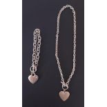 A silver toned heart necklace and bracelet measuring 8.5 inches (length) and 4.5 inches (length).