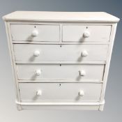 A 19th century white painted pine two-over-three chest of drawers with knob handles.