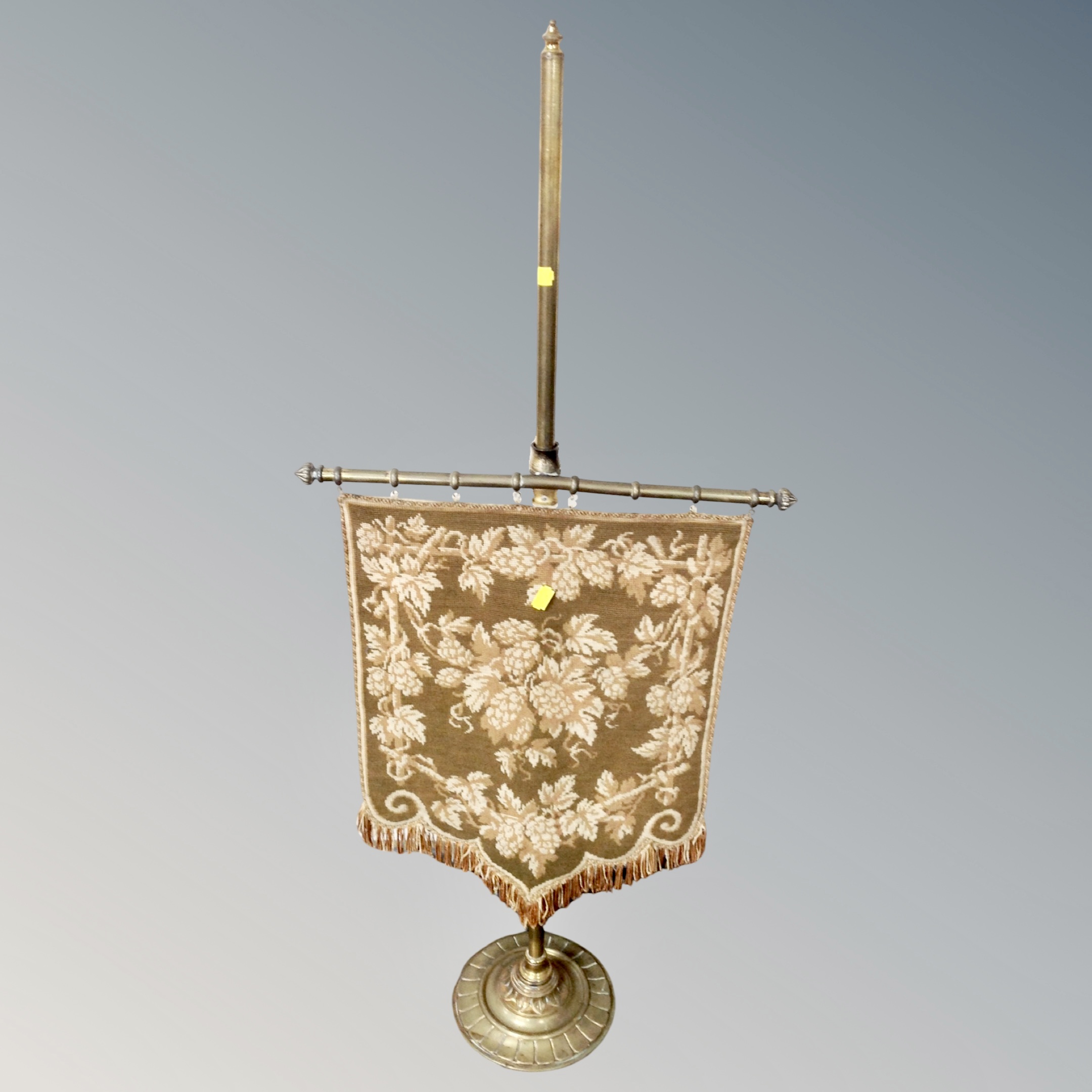 An antique brass and tapestry table pole screen.