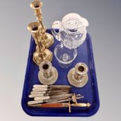 A tray containing a pair of 19th century brass candlesticks, pressed glass water jug,