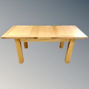 A contemporary oak pull-out dining table with leaf together with a set of six painted chairs.