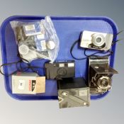 A collection of vintage cameras including a Kodak Brownie Model C and an Olympus Superzoom 160,