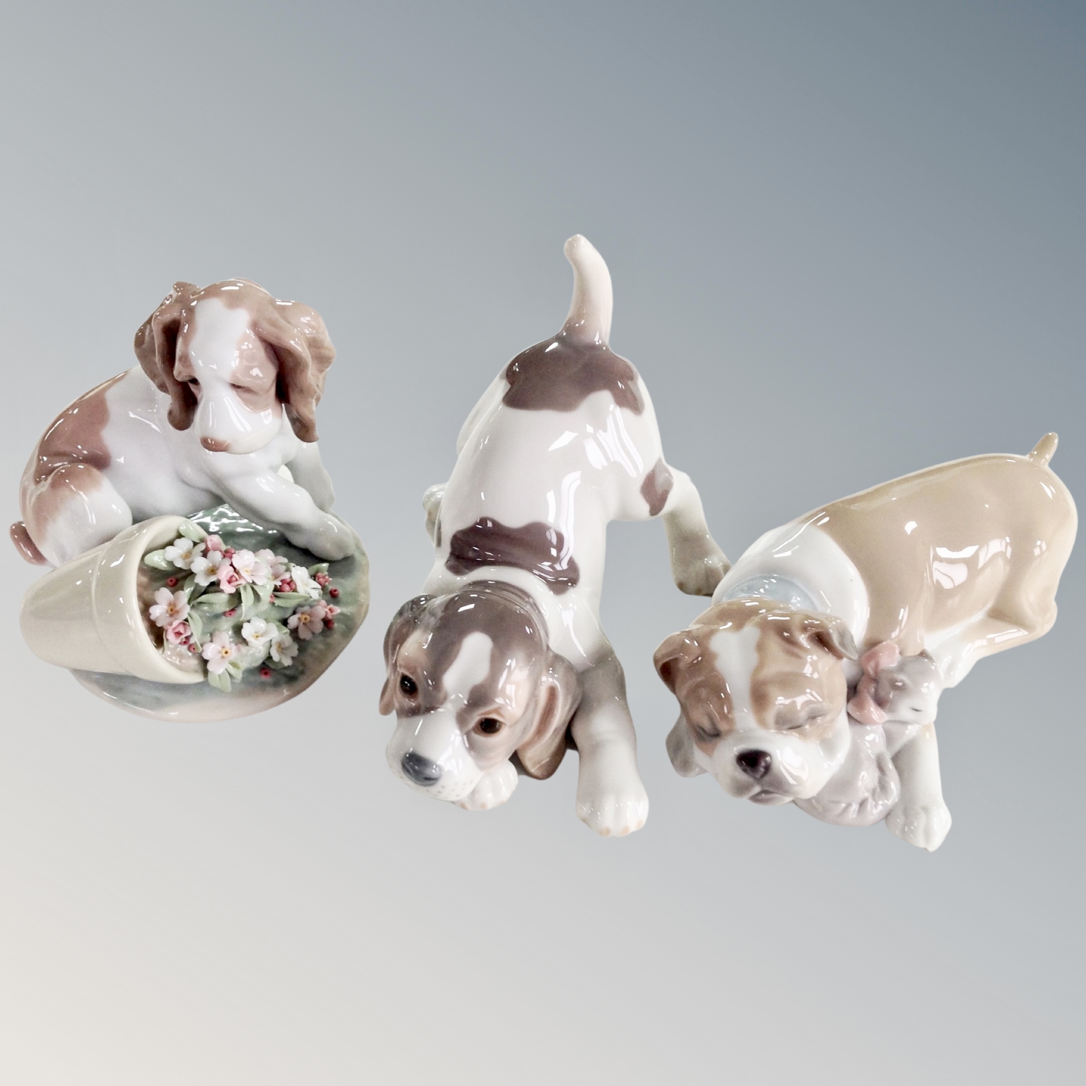 A Lladro figure, It Wasn't Me #7672, together with two further Lladro figures of puppies.