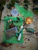 A ritual magic spell kit containing handmade votive, pentagram, incense, feather,