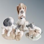 A Nao figure of a seated hound together with two further Nao figure groups, playful puppies.