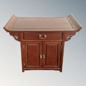 A Chinese hardwood double door altar cabinet fitted with a drawer.