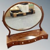 A Victorian inlaid mahogany oval dressing table mirror on stand, fitted with three drawers.