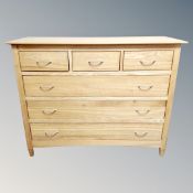 A contemporary oak three-over-three chest of drawers.