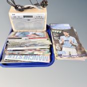 A Wharfdale DAB radio together with a quantity of Manchester City football programmes.