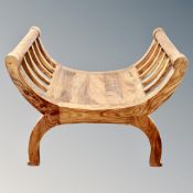 A Mango wood Regency style curved stool