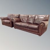 A brown leather three seater settee with matching two seater