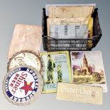 A crate of tin signs and bottle caps bearing advertising, Coca Cola, Shiner Beer,