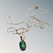 An opal cabochon set in 10ct gold on a 20'' 9ct gold chain, 1.3g.